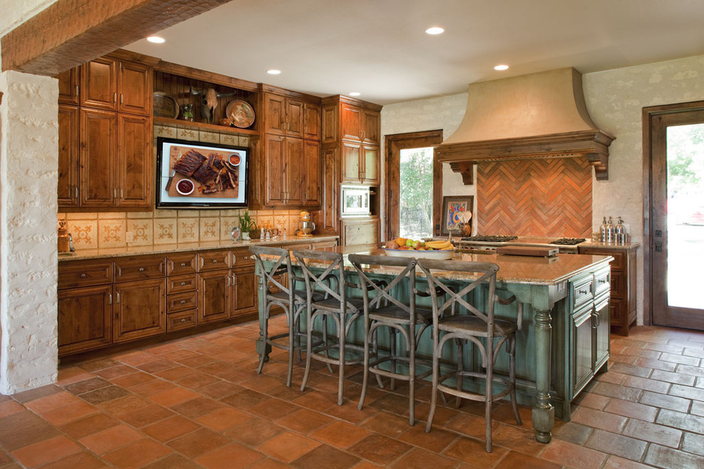 Inspiration for a mediterranean kitchen in Austin with dark wood cabinets, raised-panel cabinets and red splashback.