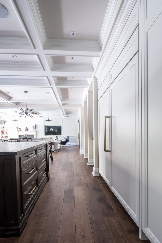 Design ideas for a large transitional u-shaped open plan kitchen in Toronto with an undermount sink, recessed-panel cabinets, granite benchtops, panelled appliances, light hardwood floors and with island.