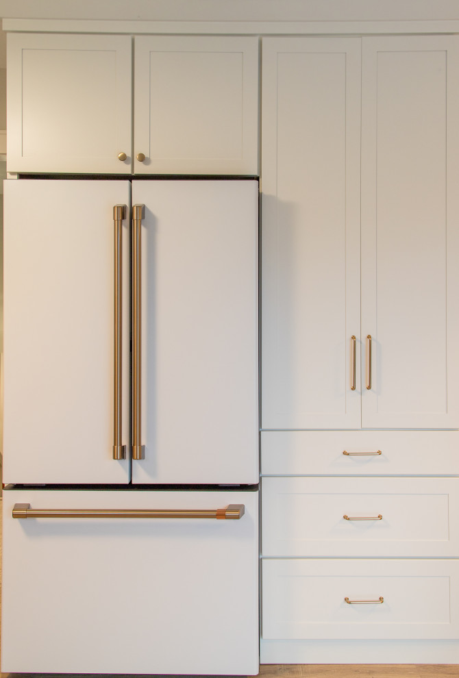Inspiration for a mid-sized transitional u-shaped light wood floor and brown floor eat-in kitchen remodel with shaker cabinets, white cabinets, white backsplash, subway tile backsplash, no island and white countertops