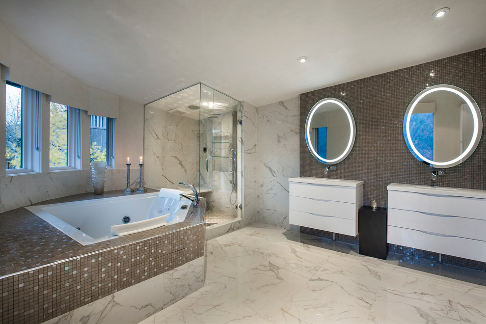 This is an example of a large contemporary master bathroom in Denver with flat-panel cabinets, white cabinets, a drop-in tub, a corner shower, brown tile, gray tile, mosaic tile, beige walls, marble floors, an integrated sink, laminate benchtops, beige floor and a hinged shower door.