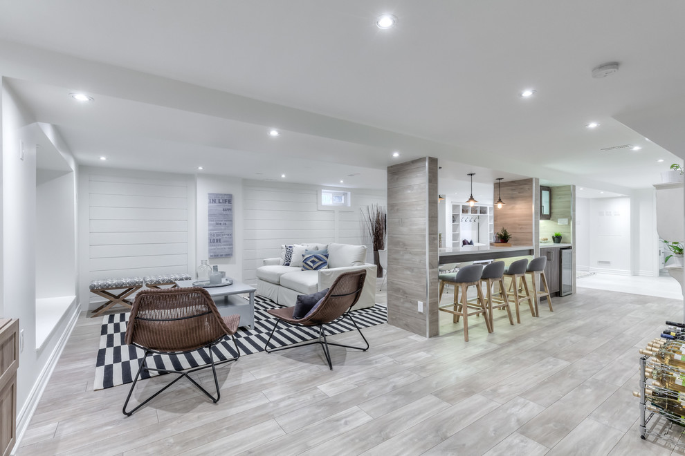 Design ideas for a large beach style walk-out basement in Toronto with white walls and laminate floors.