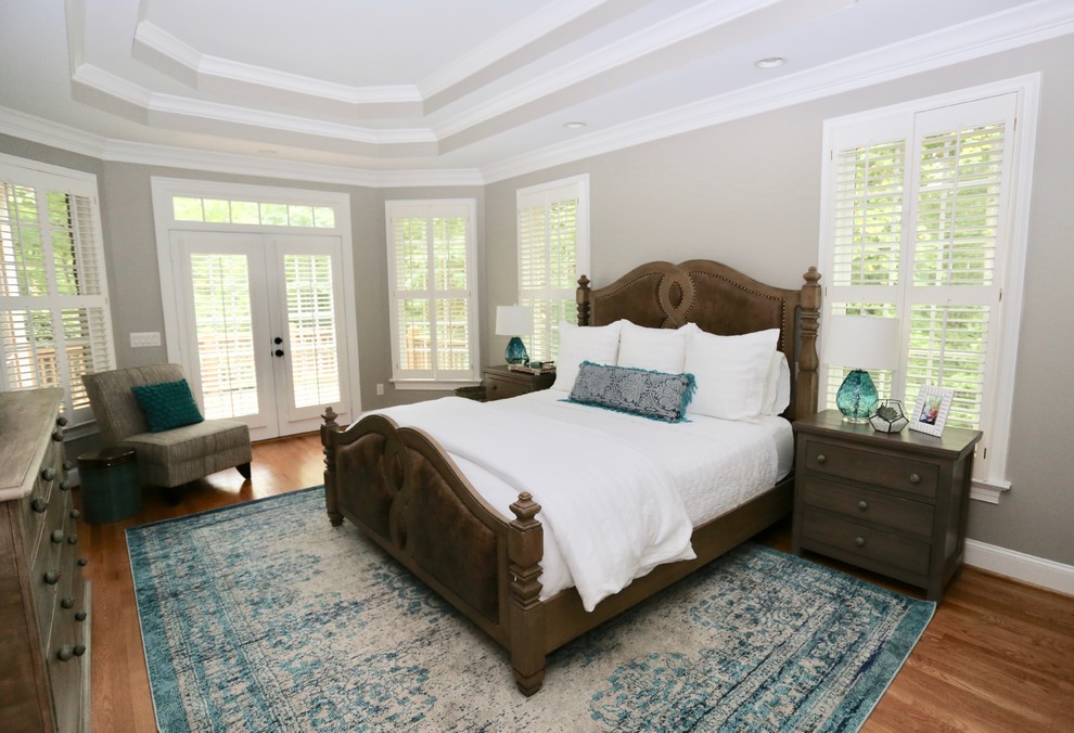 Inspiration for a large transitional master medium tone wood floor bedroom remodel with gray walls