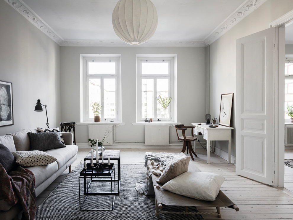 Design ideas for a traditional enclosed living room in Gothenburg with grey walls, light hardwood floors and beige floor.