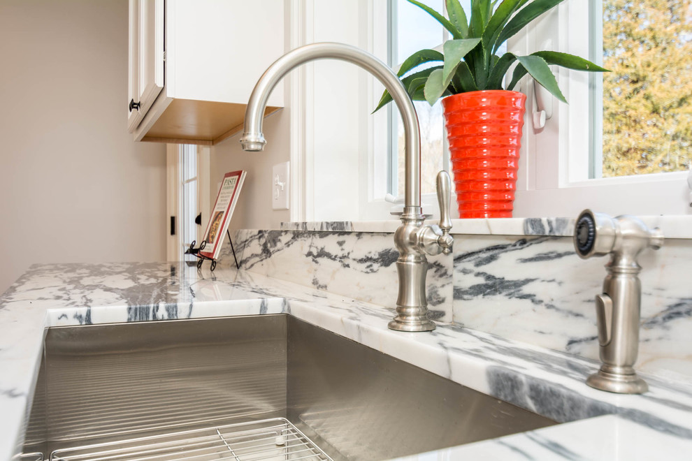 Large transitional l-shaped brown floor and medium tone wood floor eat-in kitchen photo in Boston with an undermount sink, recessed-panel cabinets, white cabinets, stone slab backsplash, stainless steel appliances, an island and quartzite countertops