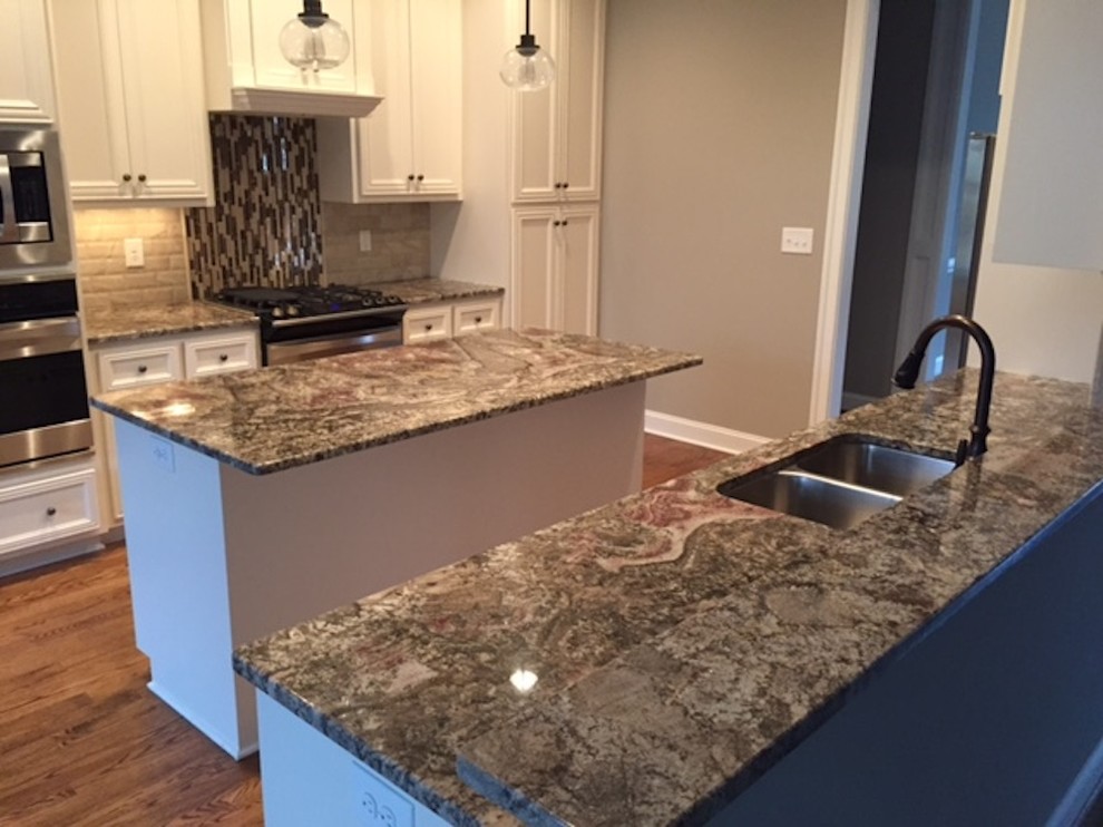 Example of a mid-sized transitional galley medium tone wood floor and brown floor eat-in kitchen design in Richmond with a double-bowl sink, recessed-panel cabinets, white cabinets, granite countertops, beige backsplash, stone tile backsplash, stainless steel appliances and an island