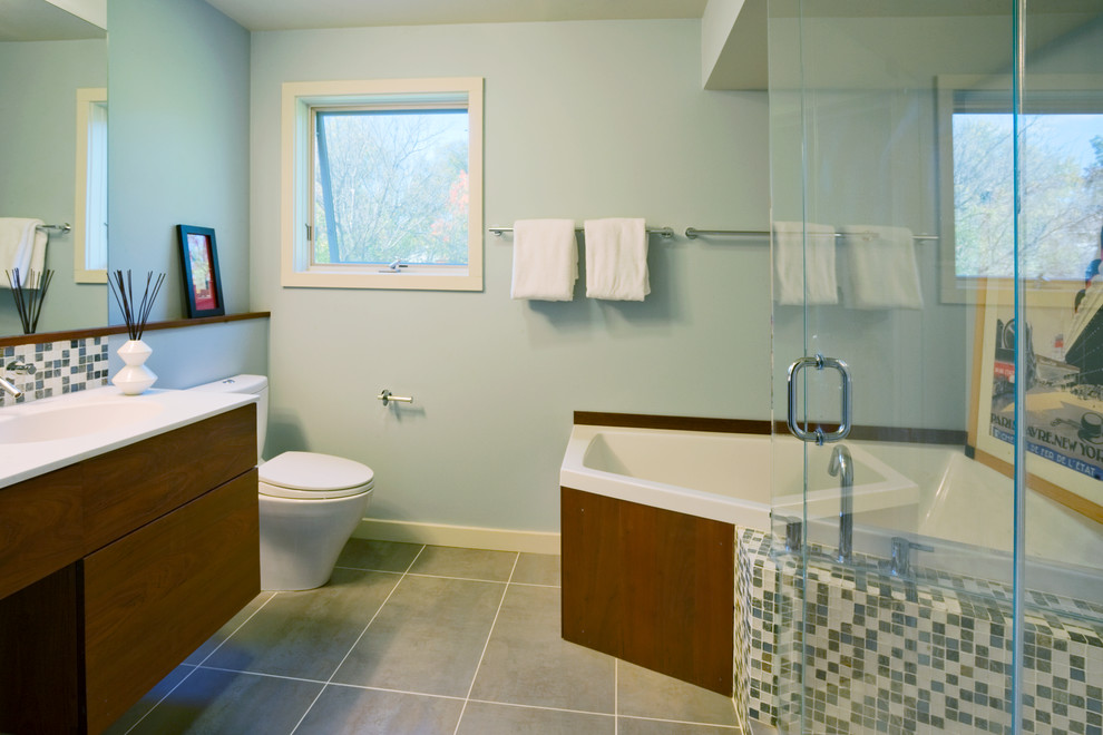 Small contemporary master bathroom in Other with an integrated sink, flat-panel cabinets, dark wood cabinets, solid surface benchtops, an alcove tub, a corner shower, a two-piece toilet, multi-coloured tile, mosaic tile, blue walls and porcelain floors.