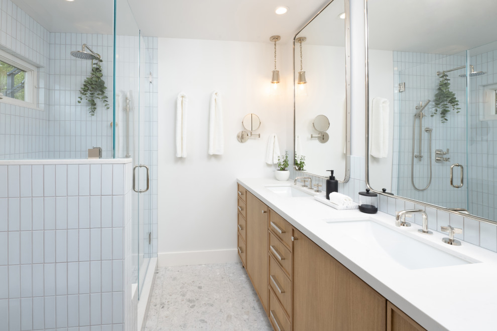 Идея дизайна: маленькая главная ванная комната в современном стиле с фасадами в стиле шейкер, светлыми деревянными фасадами, душем в нише, унитазом-моноблоком, синей плиткой, керамической плиткой, серыми стенами, полом из терраццо, врезной раковиной, столешницей из искусственного кварца, белым полом, душем с распашными дверями, белой столешницей, сиденьем для душа, тумбой под две раковины и встроенной тумбой для на участке и в саду