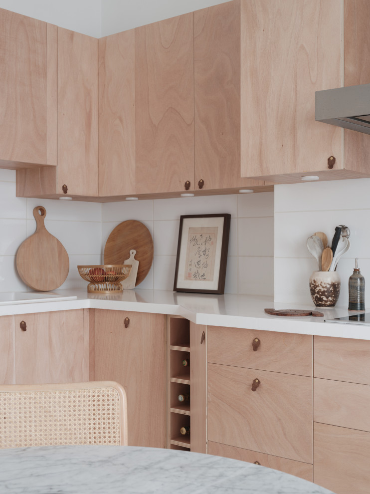 Photo of an expansive scandinavian l-shaped separate kitchen in Paris with an undermount sink, beaded inset cabinets, light wood cabinets, solid surface benchtops, white splashback, porcelain splashback, stainless steel appliances, concrete floors, no island, white floor and white benchtop.