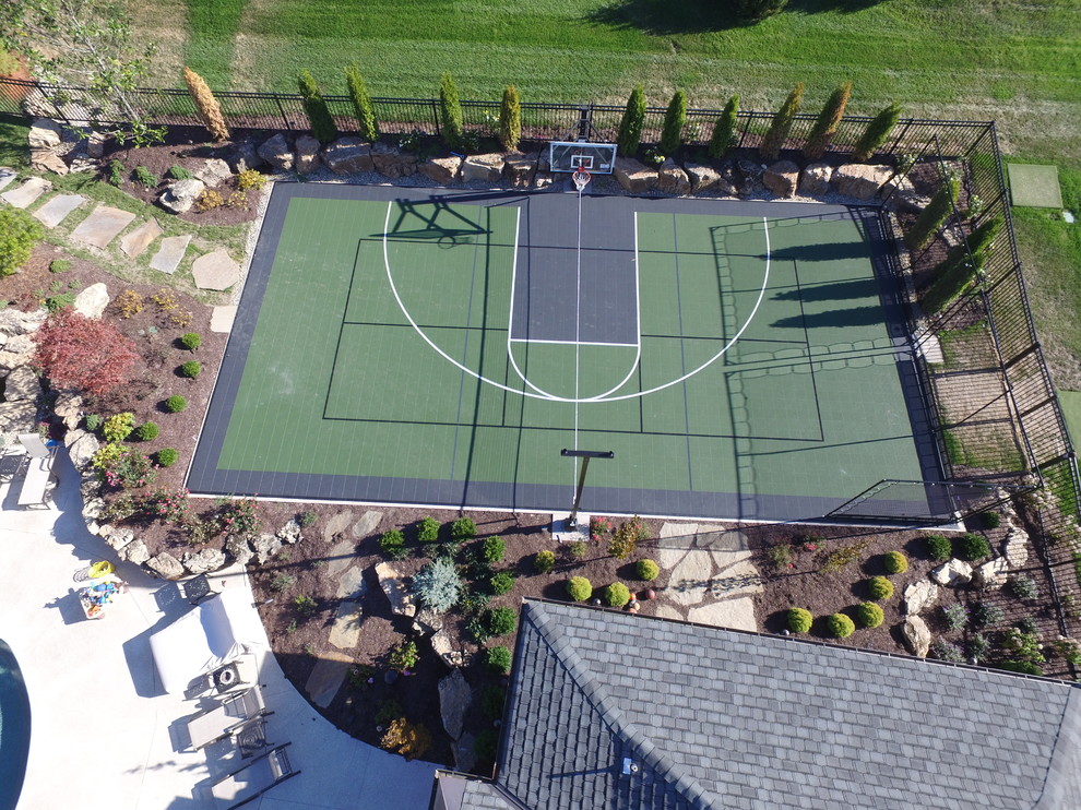 Expansive traditional backyard partial sun outdoor sport court in St Louis with a fire feature for summer.