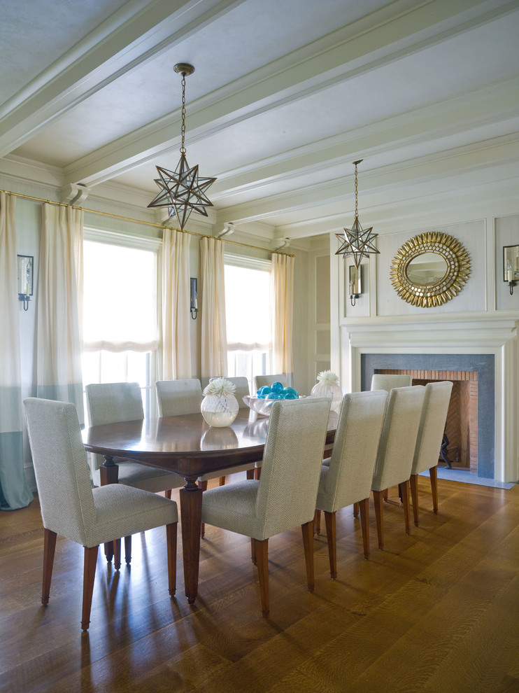 This is an example of a traditional dining room in New York with medium hardwood floors and a standard fireplace.