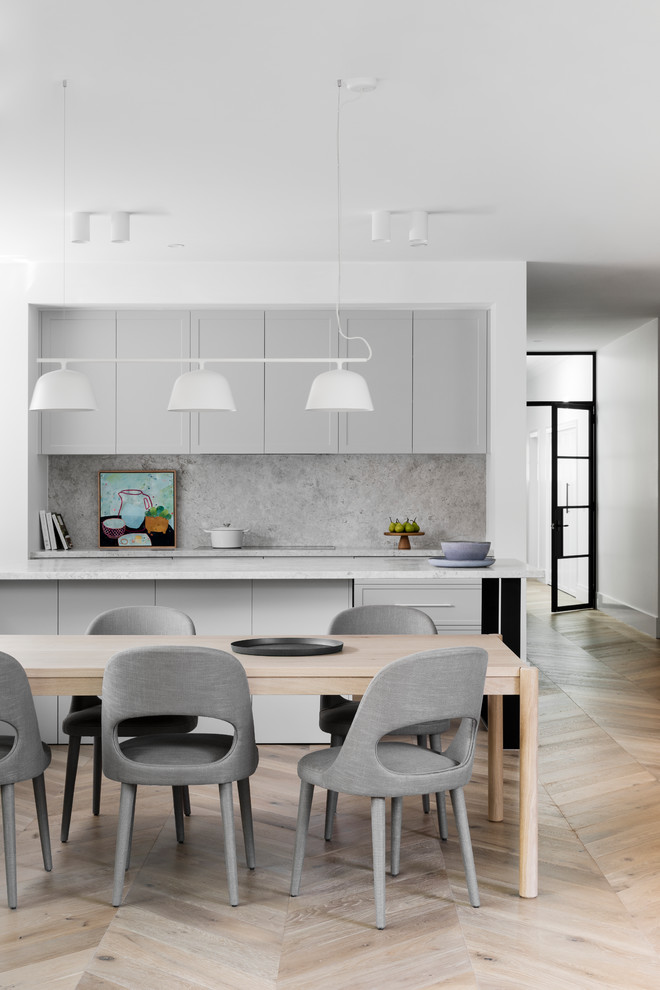 This is an example of a large contemporary open plan dining in Melbourne with white walls, light hardwood floors and beige floor.