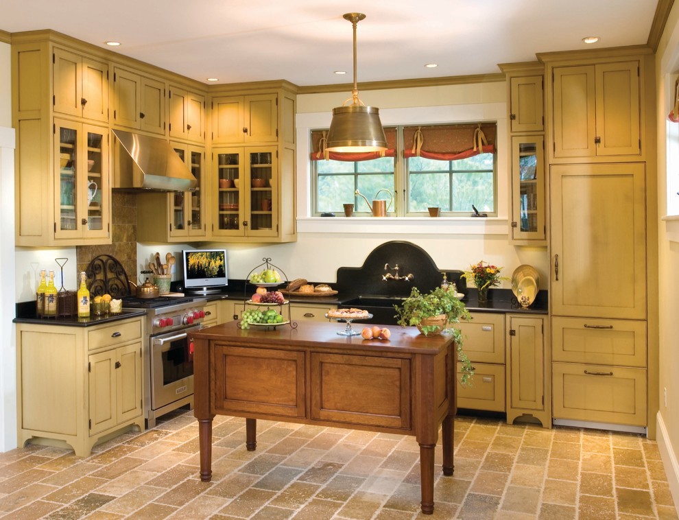 Design ideas for a small traditional l-shaped eat-in kitchen in Boston with a farmhouse sink, shaker cabinets, yellow cabinets, granite benchtops, stainless steel appliances, porcelain floors, with island, brown splashback and stone tile splashback.