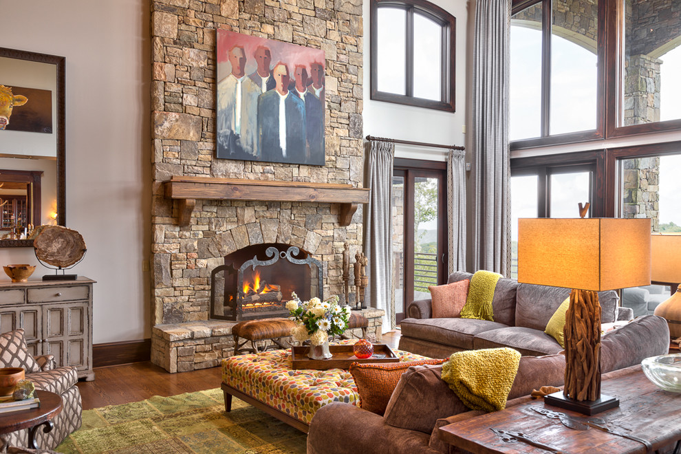 Inspiration for a mid-sized country open concept living room in Charlotte with beige walls, medium hardwood floors, a standard fireplace and a stone fireplace surround.