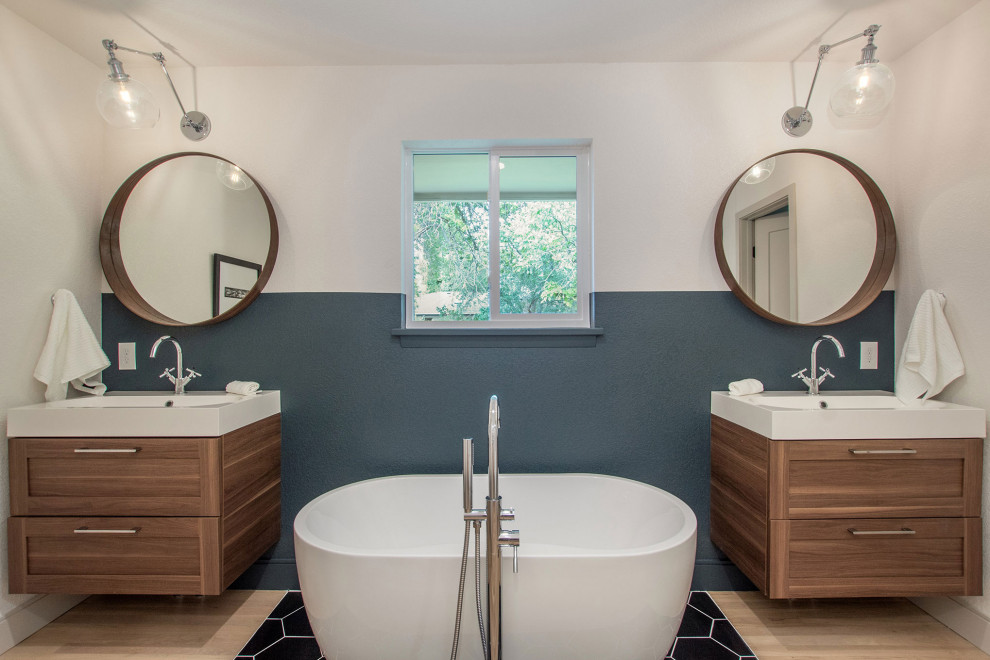 Photo of a mid-sized midcentury master bathroom in Denver with shaker cabinets, medium wood cabinets, a freestanding tub, an alcove shower, a two-piece toilet, beige tile, porcelain tile, white walls, light hardwood floors, an integrated sink, engineered quartz benchtops, beige floor, an open shower and white benchtops.