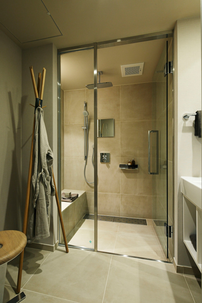 Пример оригинального дизайна: ванная комната среднего размера в стиле модернизм с открытыми фасадами, белыми фасадами, душем в нише, бежевыми стенами, полом из керамической плитки, душевой кабиной, врезной раковиной, столешницей из искусственного камня, бежевым полом, душем с распашными дверями, белой столешницей, сиденьем для душа, тумбой под одну раковину, встроенной тумбой, потолком с обоями и обоями на стенах