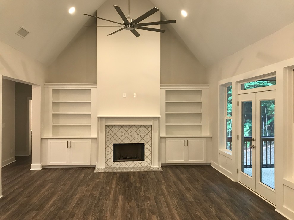 Design ideas for an arts and crafts open concept living room in Atlanta with white walls, vinyl floors, a standard fireplace, a tile fireplace surround, no tv and brown floor.