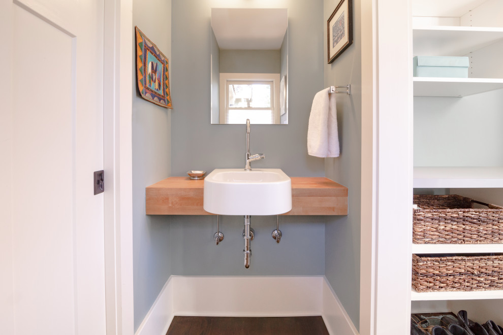Cette photo montre un petit WC et toilettes chic avec un lavabo intégré, un plan de toilette en bois, meuble-lavabo suspendu et un sol en bois brun.