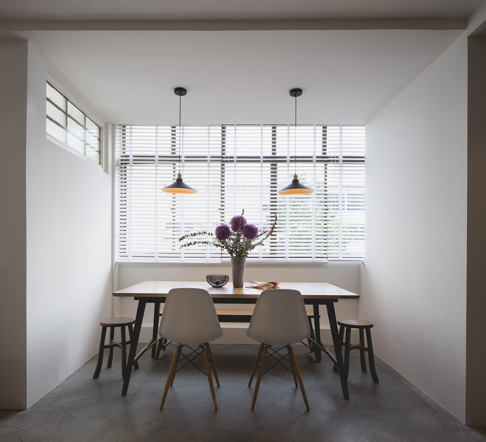 Design ideas for a contemporary dining room in Singapore with white walls and concrete floors.
