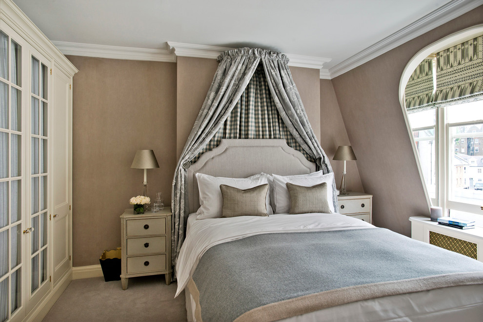 This is an example of a traditional loft-style bedroom in London with beige walls and carpet.