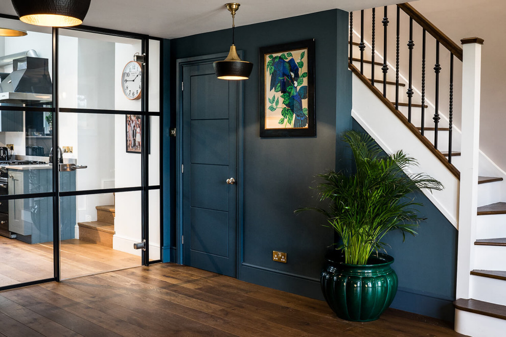 Idee per un grande ingresso o corridoio chic con pareti blu, pavimento in legno massello medio e pavimento marrone