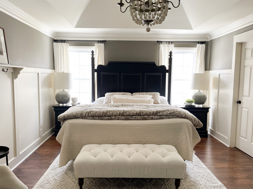 На фото: хозяйская спальня в классическом стиле с серыми стенами, полом из ламината, коричневым полом, многоуровневым потолком и панелями на стенах