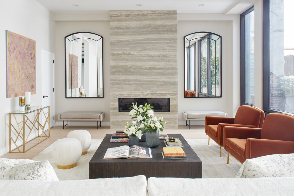 This is an example of a contemporary formal living room in New York with light hardwood floors, a ribbon fireplace, beige floor and a stone fireplace surround.