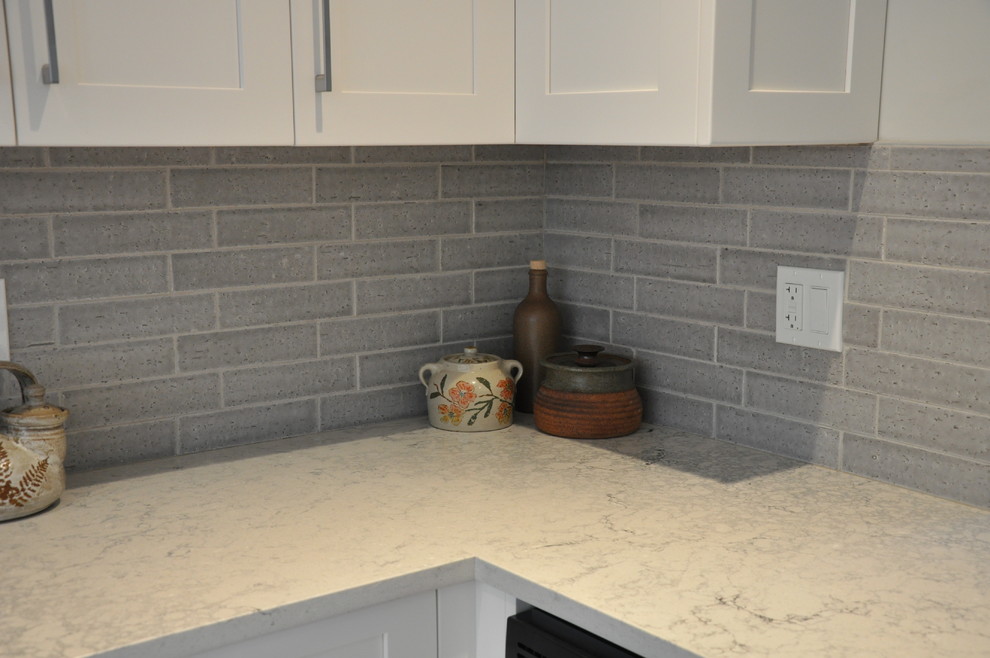 Eat-in kitchen - small transitional u-shaped vinyl floor and beige floor eat-in kitchen idea in Vancouver with a single-bowl sink, shaker cabinets, white cabinets, quartz countertops, gray backsplash, ceramic backsplash, stainless steel appliances, no island and gray countertops