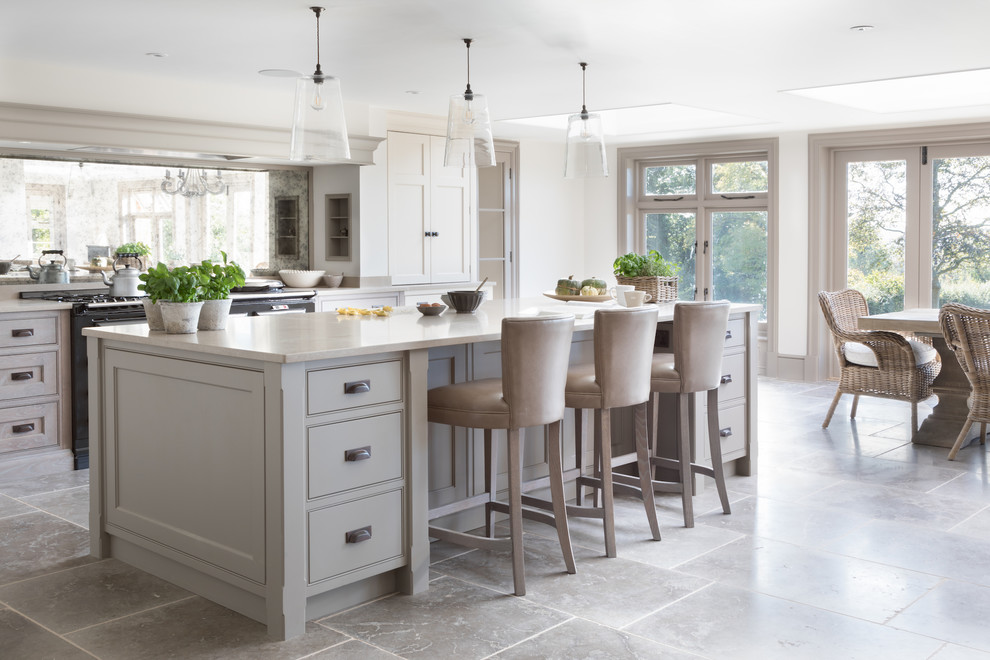This is an example of a large transitional galley eat-in kitchen in Sussex with beaded inset cabinets, grey cabinets, black appliances, with island, grey floor and beige benchtop.