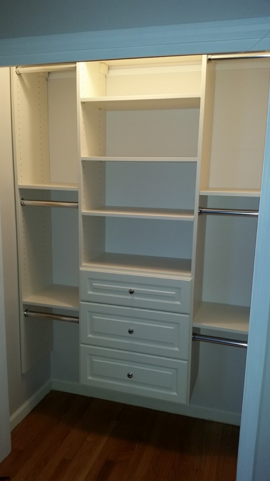 Design ideas for a small traditional gender-neutral built-in wardrobe in Boston with raised-panel cabinets, beige cabinets and medium hardwood floors.