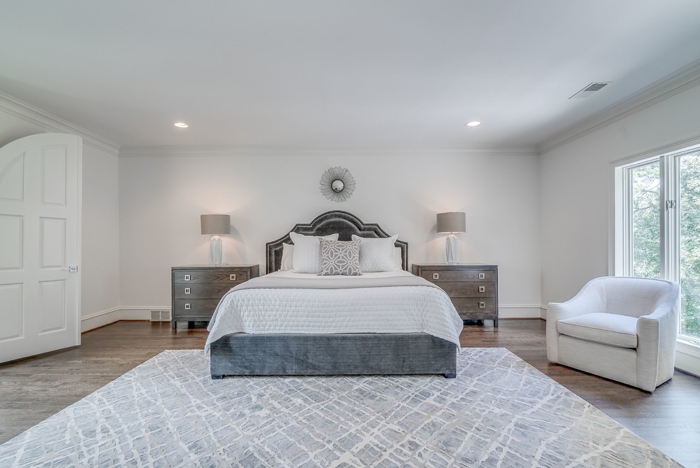 Photo of an expansive traditional master bedroom in Atlanta with white walls, medium hardwood floors, a standard fireplace, a brick fireplace surround and brown floor.