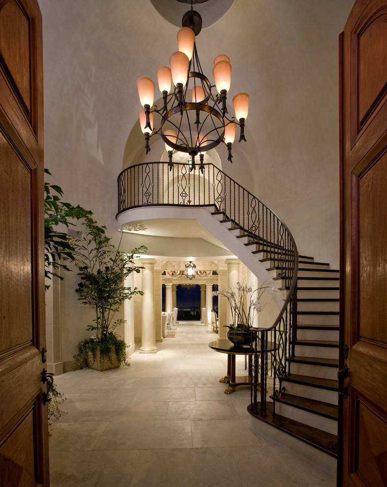 This is an example of a mediterranean foyer in Other with beige walls, travertine floors, a double front door and a dark wood front door.