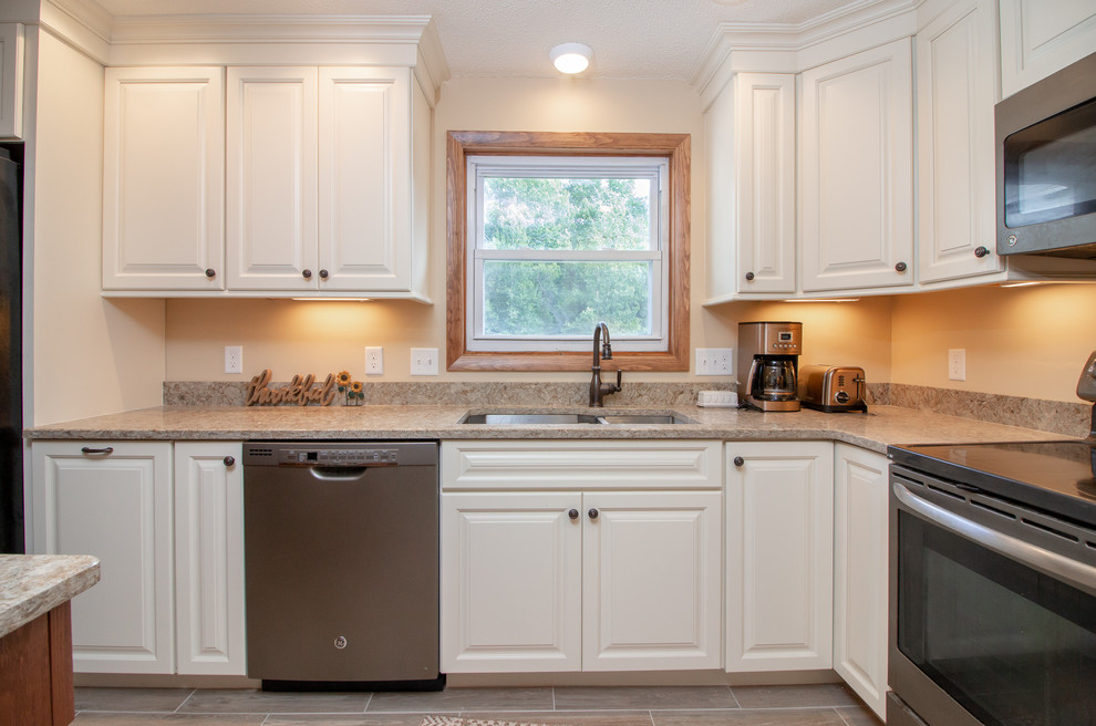 Design ideas for a mid-sized transitional l-shaped eat-in kitchen in Boston with a double-bowl sink, raised-panel cabinets, white cabinets, quartz benchtops, stainless steel appliances, porcelain floors, with island, brown floor and brown benchtop.