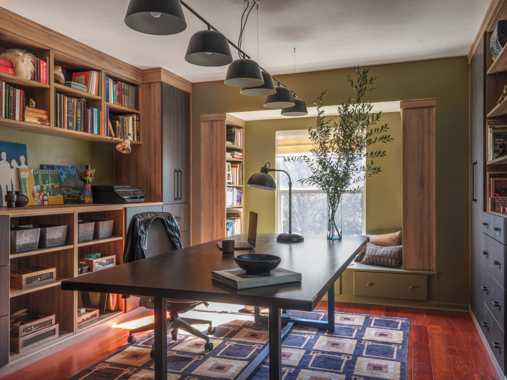 Foto di uno studio design con pareti verdi, parquet scuro, scrivania autoportante e pavimento marrone