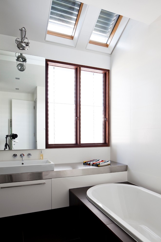 Photo of a large contemporary kids bathroom in Sydney with flat-panel cabinets, white cabinets, white tile, porcelain tile, stainless steel benchtops and grey benchtops.