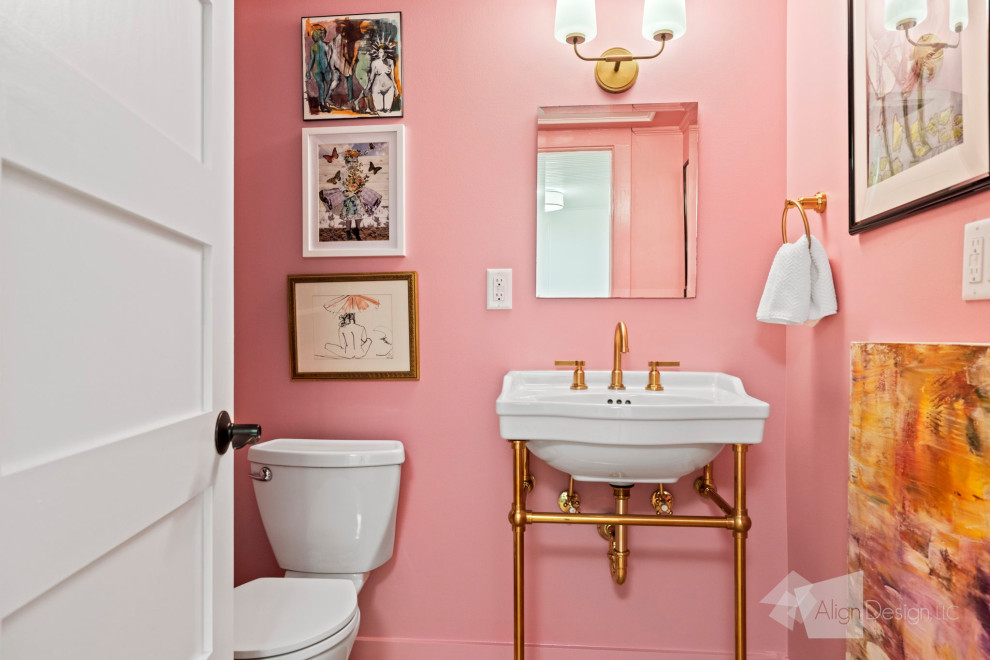 Inredning av ett eklektiskt litet toalett, med vita skåp, en toalettstol med hel cisternkåpa, rosa väggar, ljust trägolv och brunt golv
