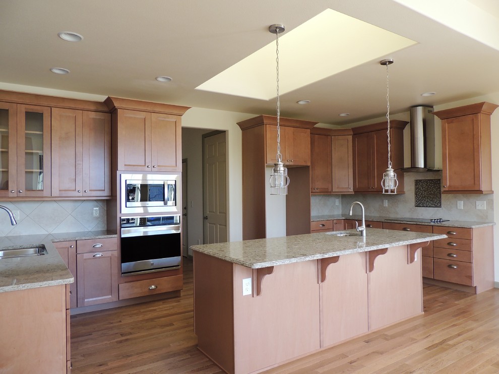 Inspiration for a large transitional u-shaped light wood floor eat-in kitchen remodel in Seattle with recessed-panel cabinets, medium tone wood cabinets, multicolored backsplash, mosaic tile backsplash, stainless steel appliances, an island and quartz countertops