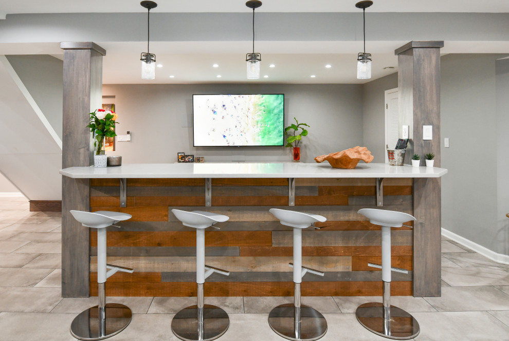 Large transitional porcelain tile and gray floor basement photo in DC Metro with a bar, gray walls, a standard fireplace and a brick fireplace