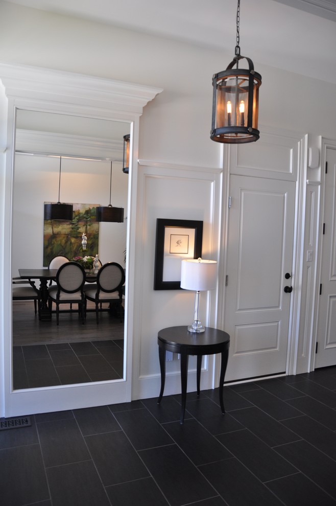 Example of a large transitional porcelain tile and black floor hallway design with white walls
