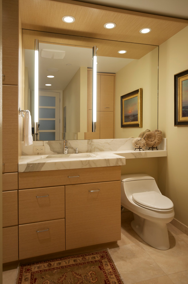 Design ideas for a small contemporary master bathroom in Other with an undermount sink, flat-panel cabinets, light wood cabinets, marble benchtops, an alcove shower, a one-piece toilet, gray tile, glass tile, beige walls and travertine floors.