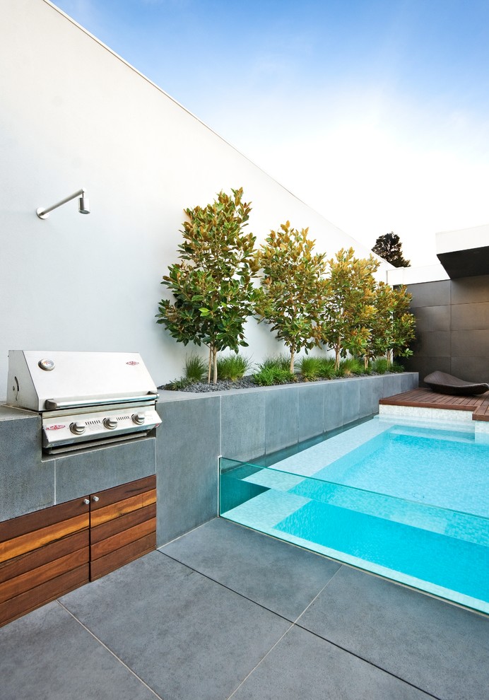 Design ideas for a small contemporary backyard rectangular pool in Sydney with natural stone pavers.