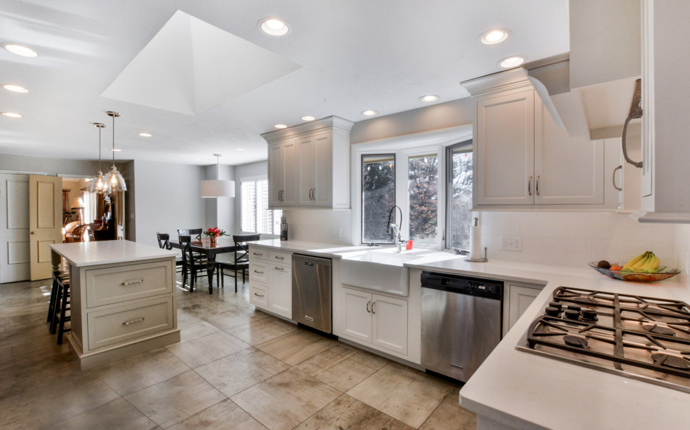 Transitional kitchen photo with white cabinets and an island