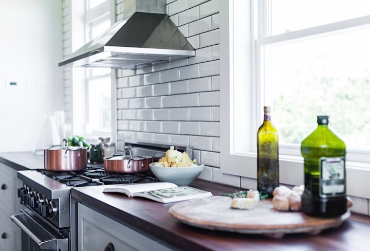Large mountain style u-shaped medium tone wood floor eat-in kitchen photo with an integrated sink, shaker cabinets, green cabinets, concrete countertops, white backsplash, subway tile backsplash, stainless steel appliances and an island