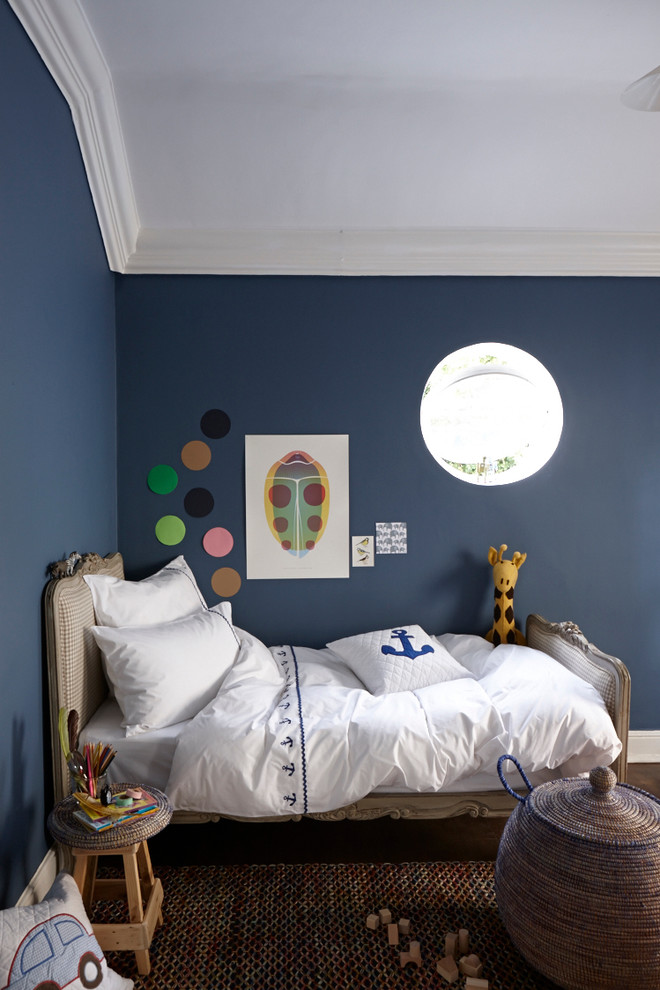 Mid-sized country gender-neutral kids' room in Berlin with blue walls and dark hardwood floors.