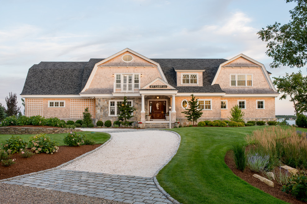 Inspiration for a large beach style two-storey beige house exterior in Boston with wood siding, a gambrel roof and a shingle roof.