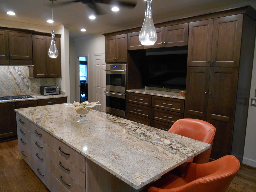 Eat-in kitchen - mid-sized transitional l-shaped medium tone wood floor eat-in kitchen idea in Birmingham with a single-bowl sink, flat-panel cabinets, medium tone wood cabinets, granite countertops, stone slab backsplash, paneled appliances, beige walls and an island