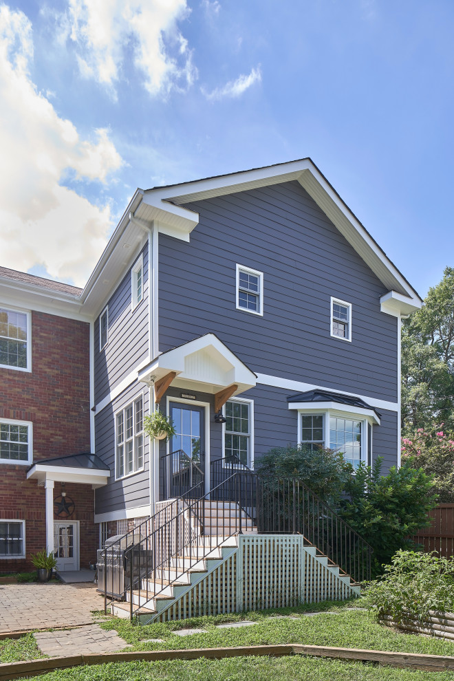 Großes, Zweistöckiges Country Einfamilienhaus mit Faserzement-Fassade, grauer Fassadenfarbe, Satteldach, Schindeldach und Verschalung in Charlotte
