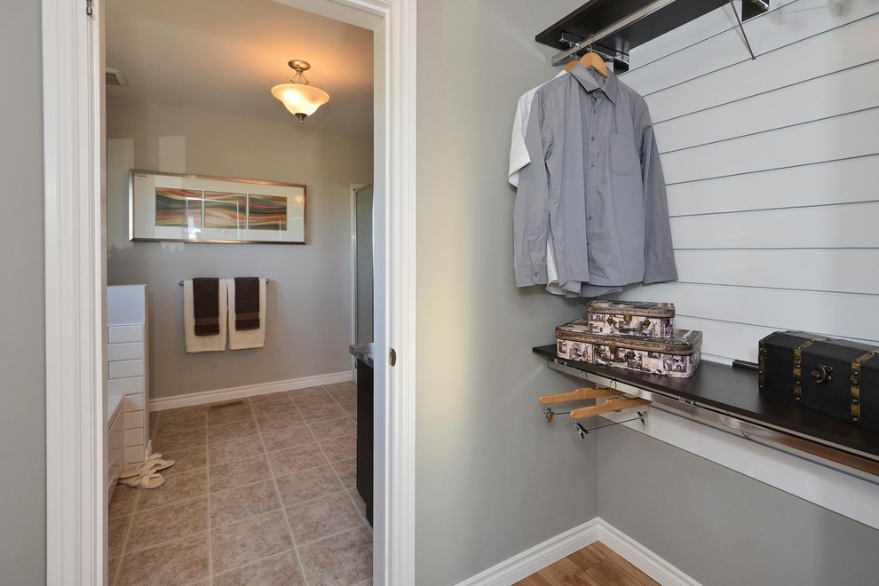 Inspiration for a traditional gender-neutral walk-in wardrobe in Toronto with medium hardwood floors and brown floor.