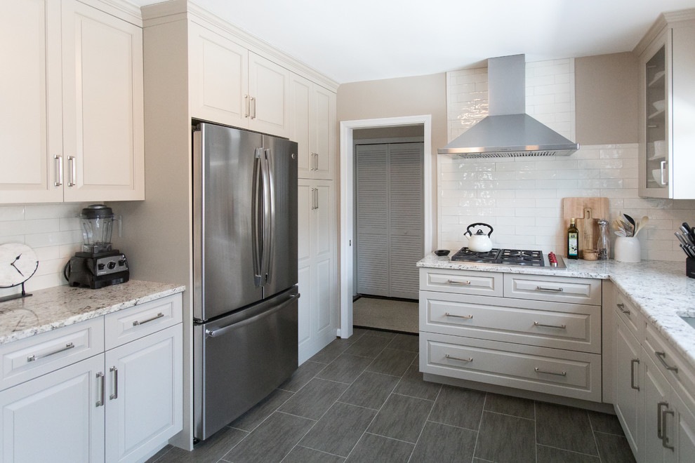 Photo of a medium sized traditional l-shaped kitchen/diner in DC Metro with a submerged sink, raised-panel cabinets, beige cabinets, granite worktops, white splashback, ceramic splashback, stainless steel appliances, vinyl flooring, no island and brown floors.