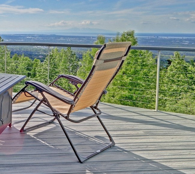 Example of a large side yard ground level cable railing deck design with no cover