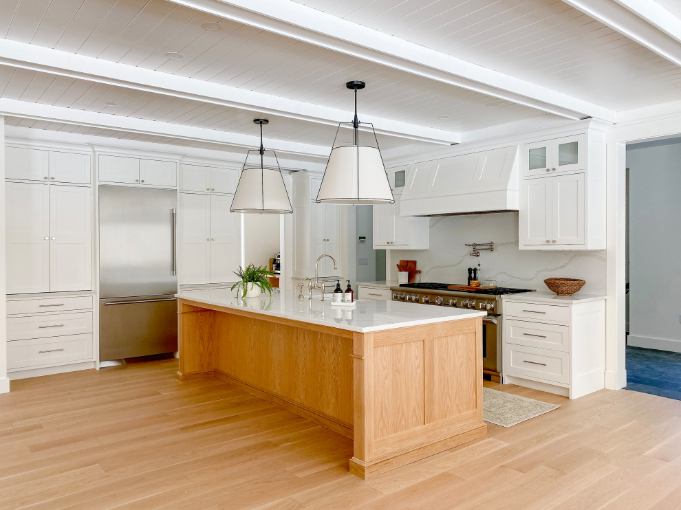 Large transitional l-shaped light wood floor and shiplap ceiling eat-in kitchen photo in Boston with a farmhouse sink, recessed-panel cabinets, white cabinets, quartzite countertops, white backsplash, stone slab backsplash, an island and white countertops